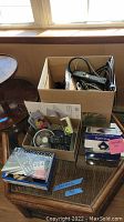 Full lot of electronics items including boxes, cables, remotes, and devices on a glass table.