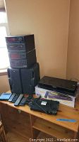 Photo showing various components on table including Panasonic Blu-Ray player, Toshiba product box, multiple remotes, and other accessories.