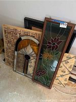 Two stained glass panels, cork boards leaning against a wall, taken from above at an angle.
