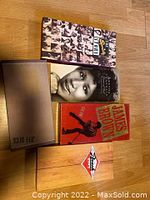 Four music box sets arranged on wooden floor showing front covers and outer packaging.