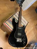 Full view of black Squier electric guitar with maple neck and rosewood fretboard showing overall design and condition.