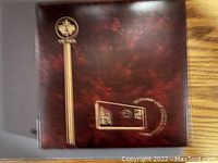 Closed album with a dark maroon cover decorated with golden postal themed art.