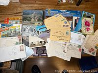 Overview of collection on wooden table showing multiple postcards and envelopes.