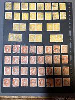 Photo of 60 Small Queens postage stamps mounted on black album page