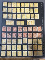 Photo showing 70 used Small Queens stamps mounted on black stock sheet, mostly 1 cent (yellow) and 3 cents (orange) denominations, with various postmarks.