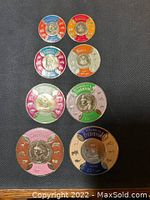 Close-up of round metallic stamps from Burundi with colorful enamel borders and face medallions in the center.