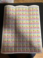 Full sheet of scout themed stamps showing multiple stamps featuring a flower emblem, bird, and torch.