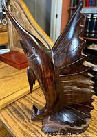 Front angled view of dark wood sailfish carving showing detailed fins and smooth finish.