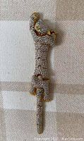 Front side view of articulated big cat brooch showing silver rhinestones and gold accents