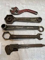 Set of 5 automotive wrenches laid out on a surface showing full lengths and inscriptions.