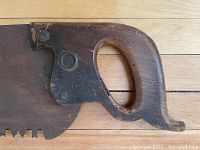 Close-up of wooden handle showing ergonomic grip and Disston logo medallion.