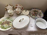 Overview of the fine china set showing cups, saucers, plates, bowls, and covered serving pieces arranged on a table.