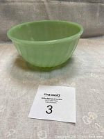 Side angle showing the pale green translucent glass bowl with swirling ribbed exterior pattern and no chips or damage visible.