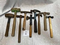 Photo showing all nine old hammers laid out on fabric background for full lot view