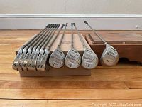 Full set of Wilson ProStaff irons and woods lined up horizontally showing club faces from 4 iron through pitching wedge and 3, 5, 7 woods.