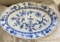 Large oval antique Meissen porcelain platter with blue floral decorations on white background, showing entire top side
