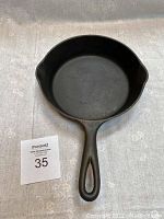 Top view of cast iron skillet showing cooking surface, handle, and dual pouring spouts.