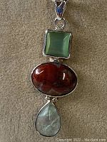 Full view of pendant showing three stones and chain