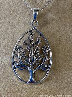 Front view of teardrop-shaped sterling silver Tree of Life pendant on chain showing intricate branch and leaf design.
