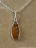 Front view of the sterling silver pendant with Baltic amber stone on chain.