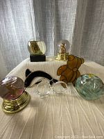 Full group of eight decorative glass items on white fabric background.