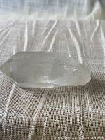 Side view of a natural pointed quartz crystal showing transparency and natural points.