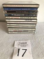 Stack of 12 music CDs showing spine titles including Chris de Burgh, Luther Vandross, Big Bad Voodoo Daddy, Vince Gill, Rodney Crowell and others.