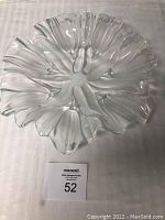 Clear glass 13-inch serving platter with frosted tulip petal shapes radiating outward, photographed on a fabric surface.