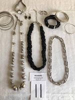 Full view of the costume jewelry lot showing various necklaces, bracelets, earrings, and a small watch