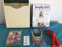 Overview photo showing Zenith scale, Simply Keto guidebook, Xbox One Zumba Fitness game, replacement Fitbit Flex wristbands, and red jump rope.