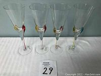 Front view of four vintage Romanian glass flutes with colorful swirl accents on stems and bases.