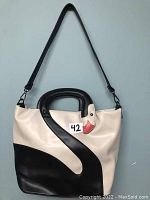 Full view of the cream and black purse with swan design and detachable shoulder strap