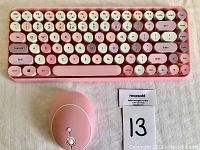 Top view of mini wireless keyboard and wireless mouse placed on a white background with lot number card