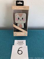 Front view of Catchy Cat wireless speaker in original packaging showing cat design and branding details.