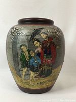 Side view of antique vase displaying hand-painted figures and floral motifs
