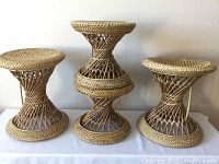 Front view showing all four bamboo stools on white surface