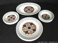 Set of oval platter, four dinner plates, four bread plates, and five soup bowls with autumn leaf motif and geometric border on white ironstone.