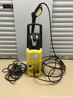 Full view of the Karcher pressure washer with attached trigger gun and power cord.