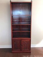 Front view showing entire bookcase with three shelves and bottom cabinet