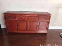 Full view of the vintage rosewood buffet showing four drawers and four cabinet doors, polished surface, and visible wood grain.