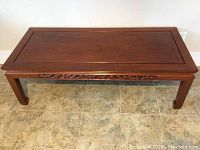 Top view of rectangular rosewood coffee table showing smooth polished surface and bradded edge