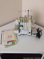 Front and left angle view of Singer Ultralock 14 U64A serger sewing machine with thread stand and foot pedal on white table, instruction manuals stacked beside.