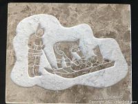 Top view of soap stone carving showing figure and sleigh, signature visible in lower corner.