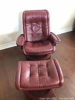 Front view of chair and footstool showing overall condition and appearance