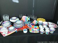 Full spread showing all pieces including glasses, plates, bowls, fish decor, placemats, and trays arranged on table