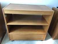 Front view of teak shelf unit showing two shelves and drawer below.