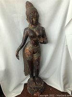 Full front view of statue showing overall form, pedestal and surface wear