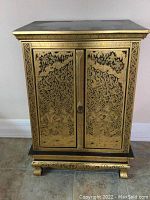 Front view showing two gold stencil decorated doors and overall design.