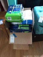 Box open showing multiple packages of adult disposable underwear including Prevail Daily Briefs 16 count