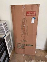 Cardboard box of the cheval mirror showing printed product information, including cherry finish and item number 7028.